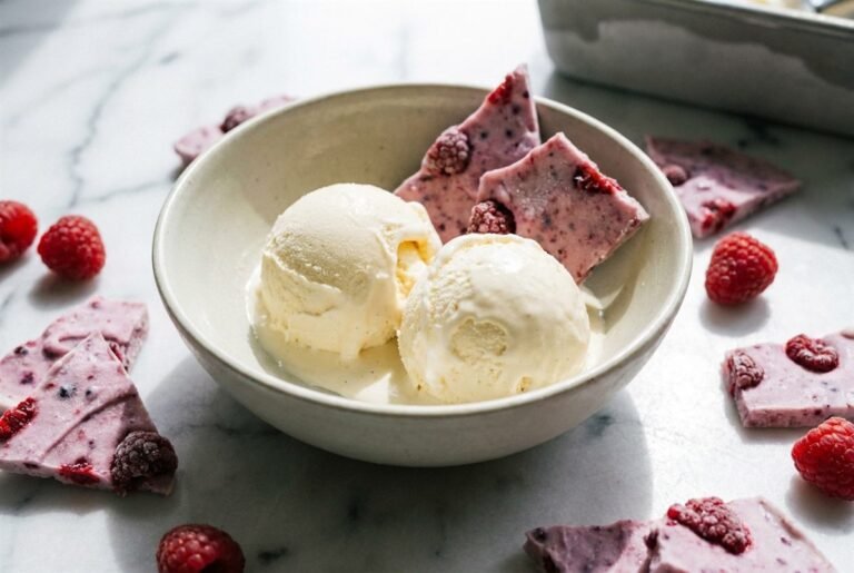 Scoops of no-churn ice cream beside frozen berry yogurt bark on a bright summer day.