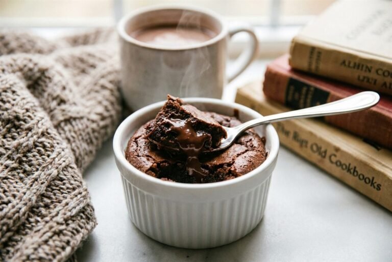 A single-serve fudgy brownie in a ramekin with a spoon and melty chocolate.